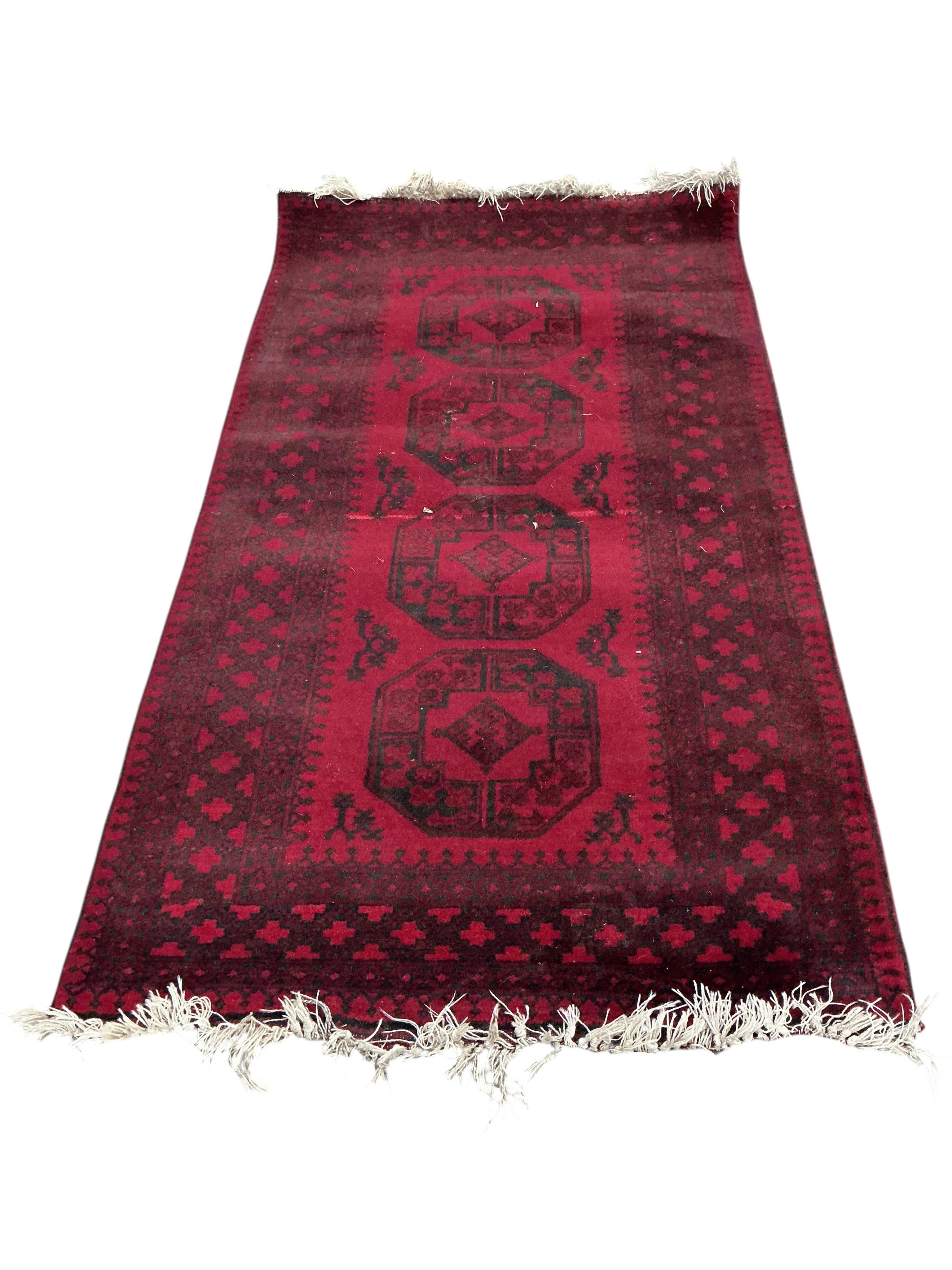 An Afgahn red ground wool rug, 200 x 108cm